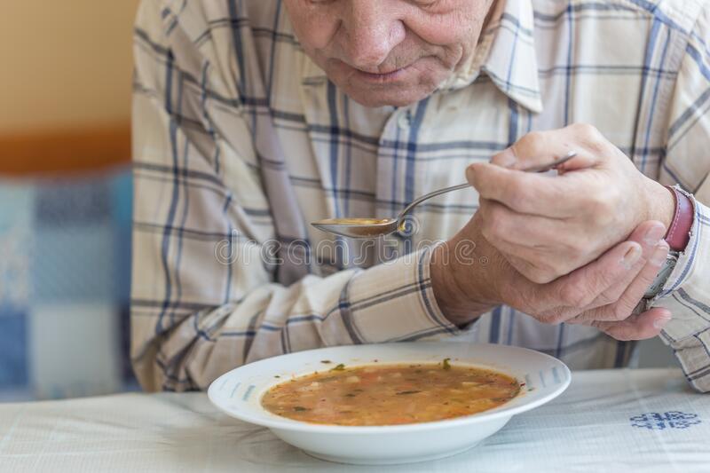 Elderly Man With Parkinsons Disease Holds Spoon In Both ...
